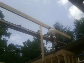 Carpenter setting a ridge beam over a new addition frame — Ice Dam Removal by Roofing Brothers in Whiteland