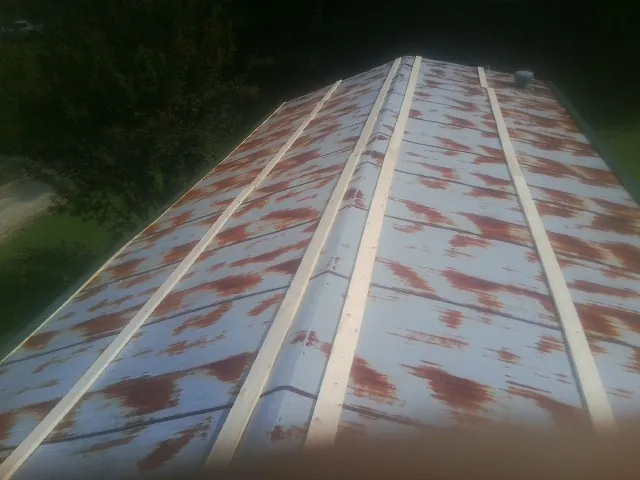 Rusted metal roof panels with new wood purlins before replacement — Storm Damage Roof Repair in Whiteland by Roofing Brothers