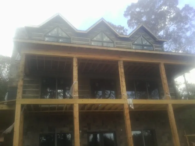 Dormers and porch framing on a large log home under construction — Roof Coating work by our crew in Whiteland