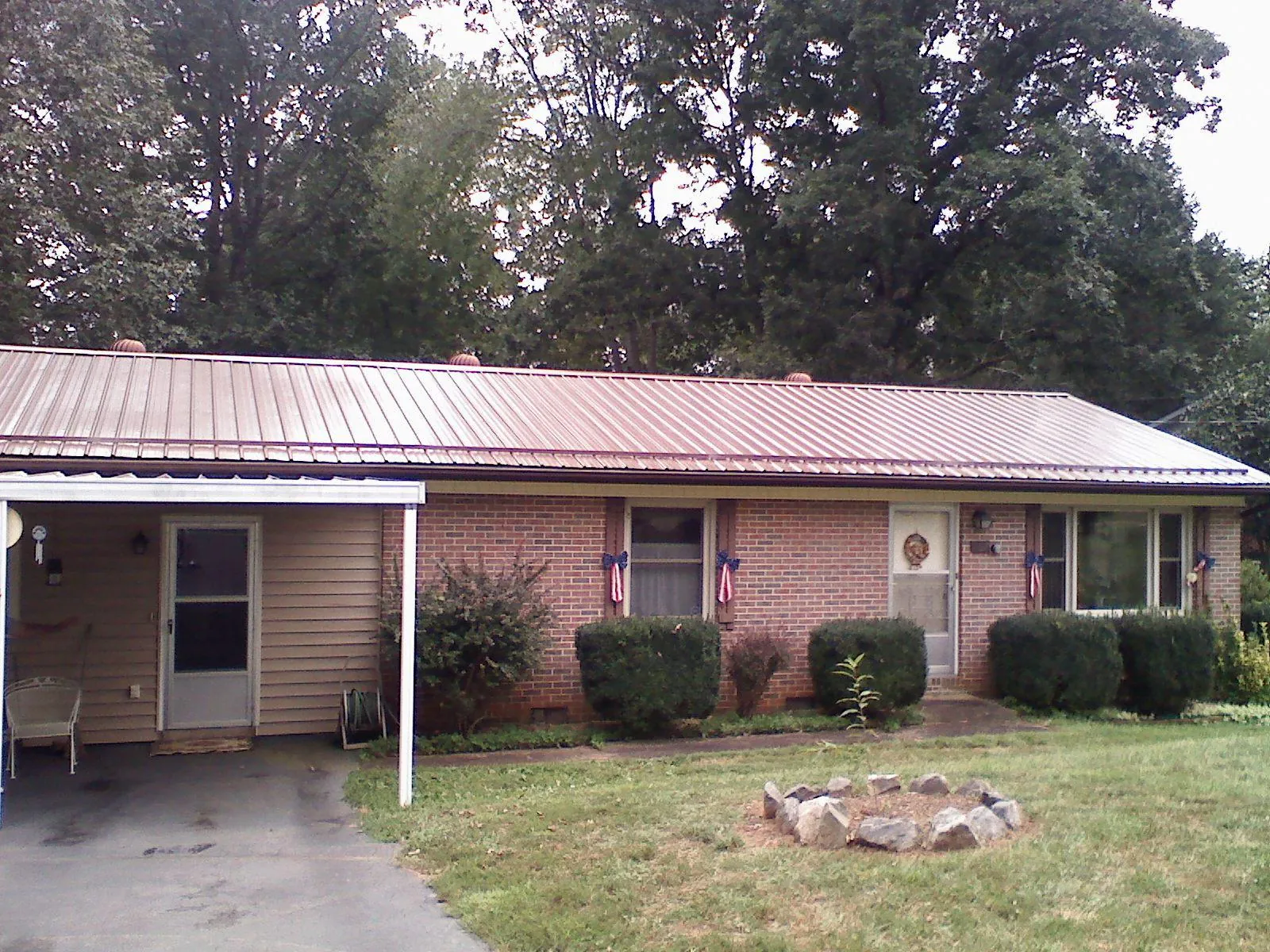 Bronze metal roof and carport on a brick ranch home — Roof Repair work by our crew in Whiteland