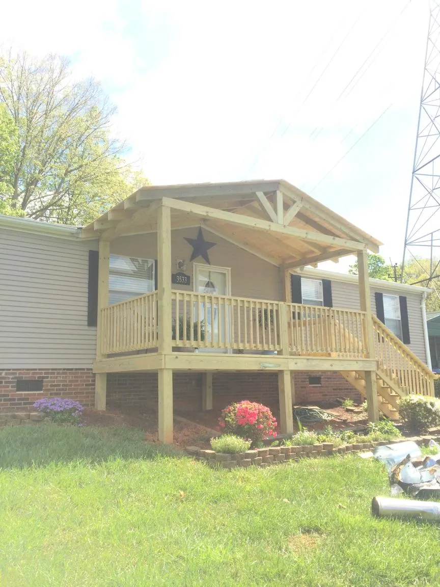 New gabled porch roof and deck railing added to a ranch home in Whiteland